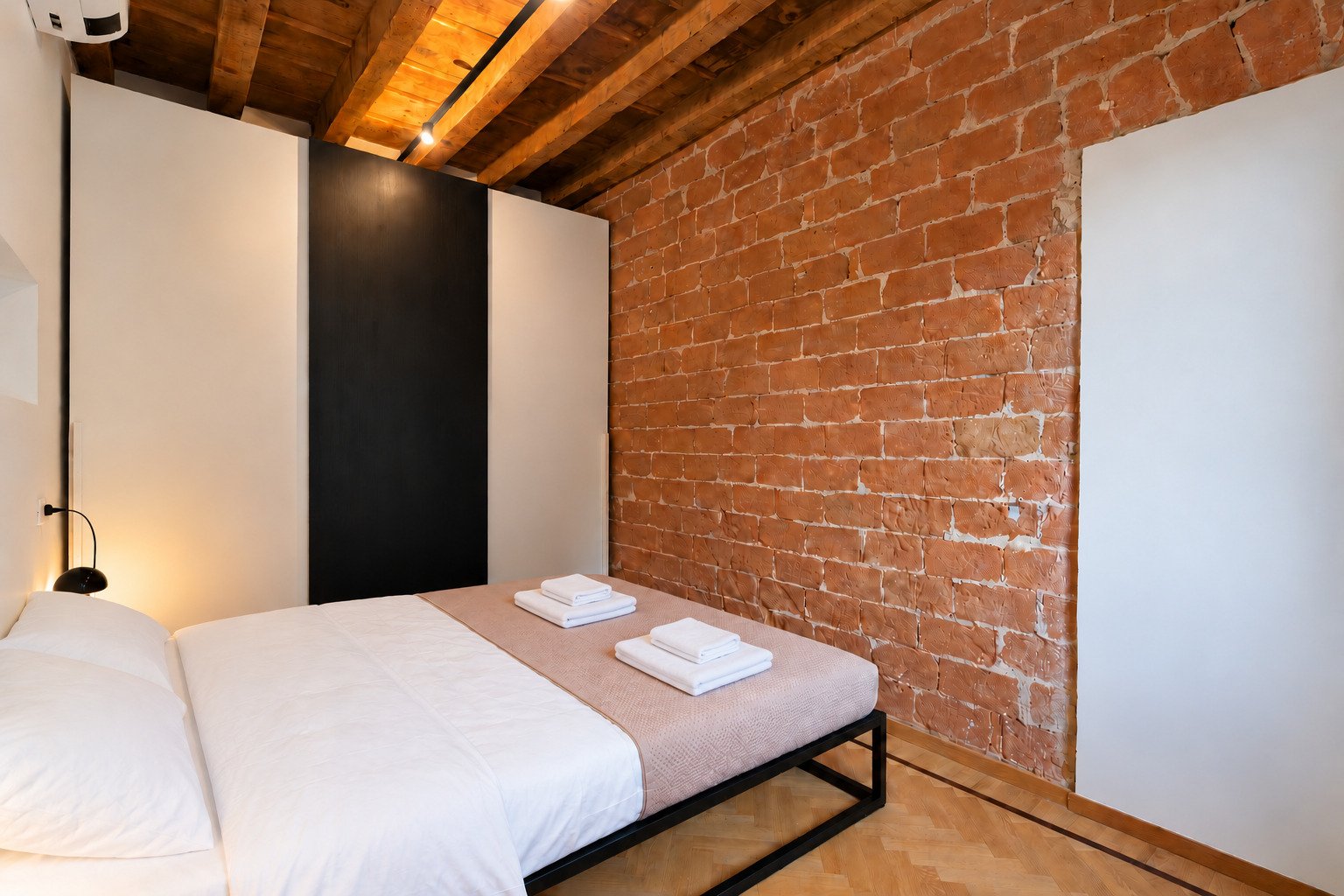 Casa Asnago e Vender — la camera e il muro in mattoni a vista