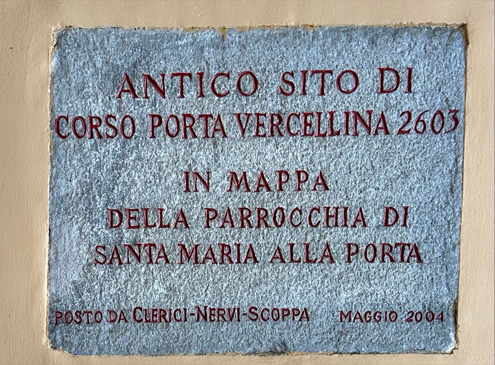 La targa nell'androne: Antico sito di Corso Porta Vercellina 2603, in mappa della parrocchia di Santa Maria alla Porta